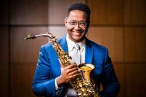 Portrait of Steven Banks holding a Saxophone.